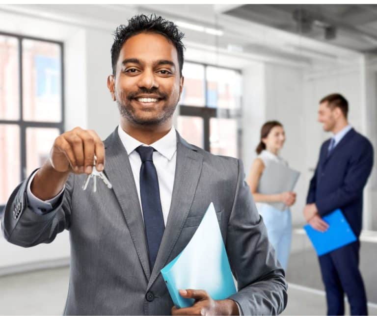 A man in suit holding a key and a folder