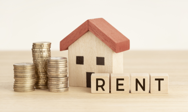 buying vs renting - miniature house next to quarters and the word rent