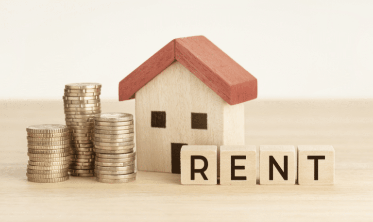 buying vs renting - miniature house next to quarters and the word rent